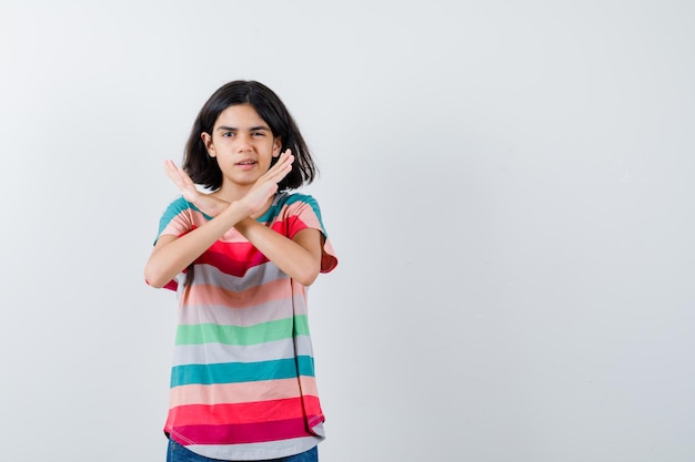 Free photo portrait of little girl showing refusal gesture in t-shirt and looking confident front view