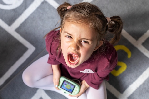 Free photo portrait little girl upset because of the game