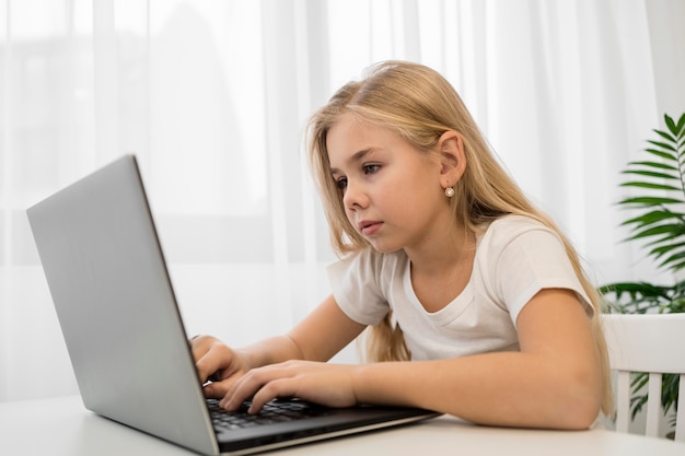 Free photo portrait little girl using laptop