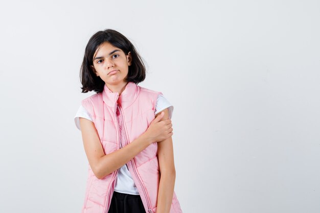 Portrait of a little girl in white t-shirt and puffer vest