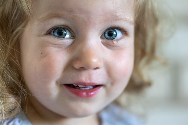 큰 파란 눈, 눈물로 얼룩진 아이의 눈을 가진 어린 소녀의 초상화.