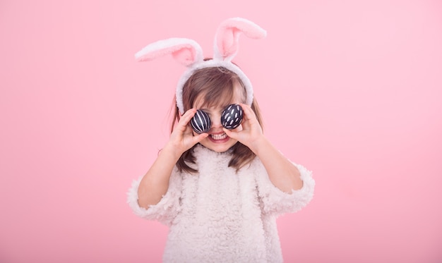 Portrait of a little girl with bunny ears and easter eggs