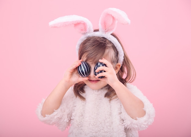 Free photo portrait of a little girl with bunny ears and easter eggs