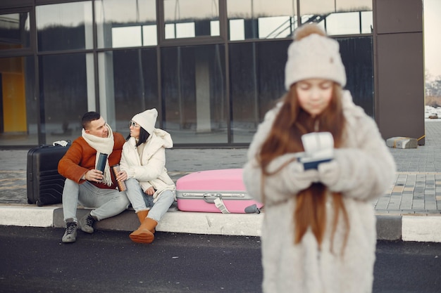 Portrait of a little girl with passports and her parents behind