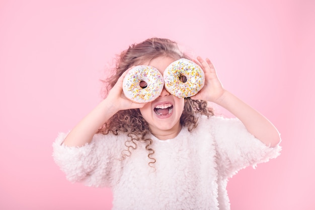Portrait of a little smiling girl with donuts
