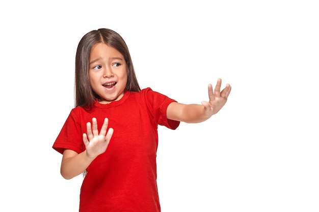 赤いTシャツで怖がって興奮している小さな驚きの女の子の肖像画。白い背景に分離