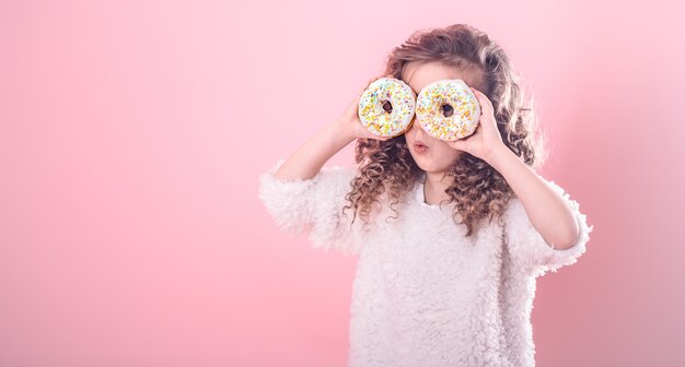 Портрет маленькой удивленной девушки с пончиками