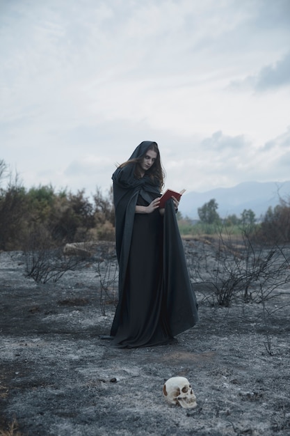 Portrait of a long haired guy with book and skull