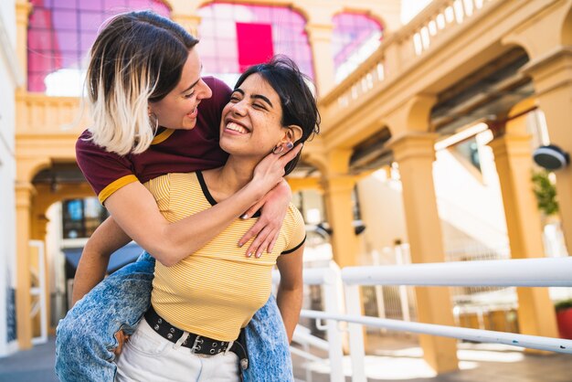 Portrait of lovely lesbian couple spending time together and having fun at the street. LGBT concept.