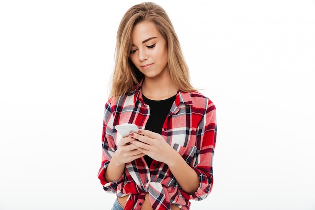Portrait of a lovely pretty girl in plaid shirt texting
