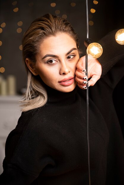 Portrait of lovely woman in black sweater standing and posing.