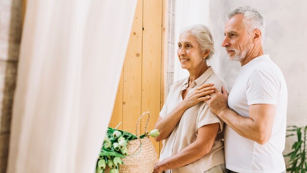 Portrait of loving happy senior couple looking away