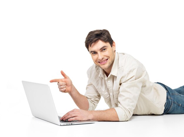 Portrait of a lying man with laptop and points on the screen isolated on white.