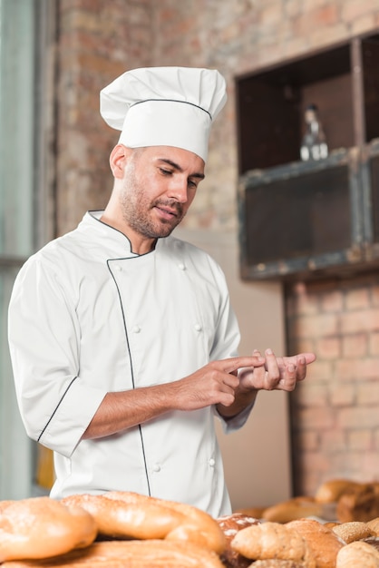 Portrait of male baker counting baked breads