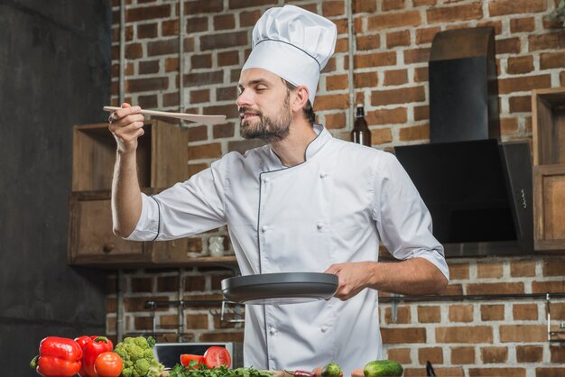 準備された食べ物の匂いを楽しむ男性のシェフの肖像