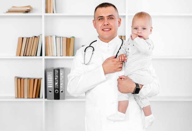 Portrait of male doctor holding a baby