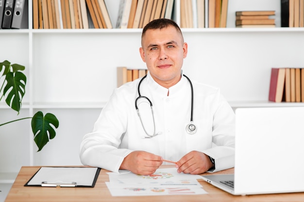 Portrait of male doctor sitting on desk