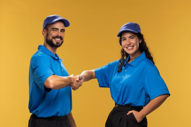 Portrait of male and female deliverers handshaking each other and smiling