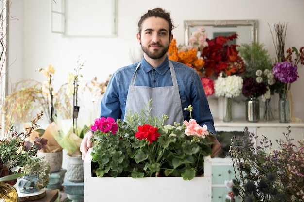 カラフルなアジサイの花を木枠に保持している男性の花屋の肖像画