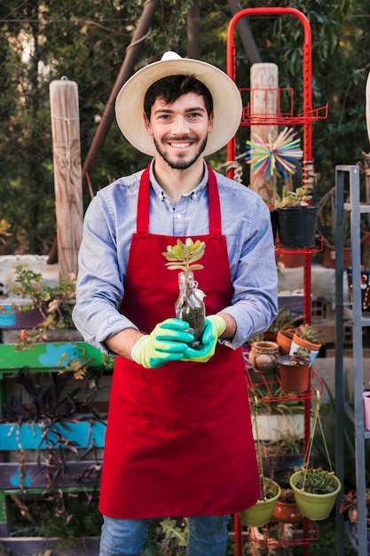 Portrait of a male gardener holding cactus plant in hand