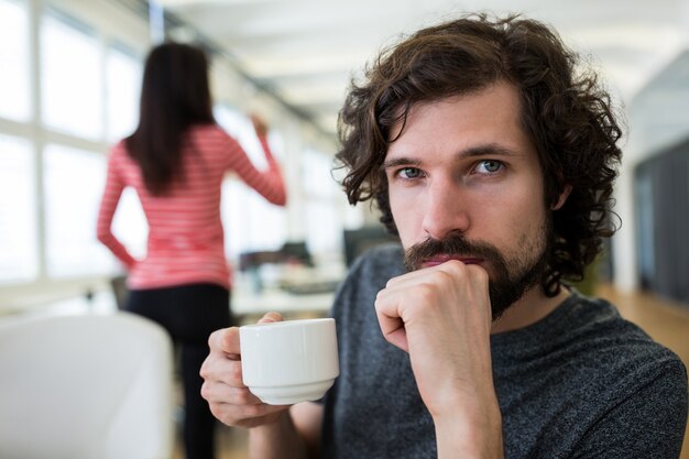 コーヒーカップを保持している男性のグラフィックデザイナーの肖像