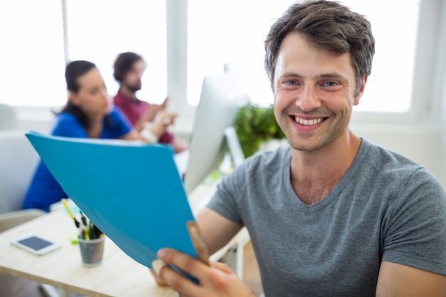 Portrait of male graphic designer holding a file