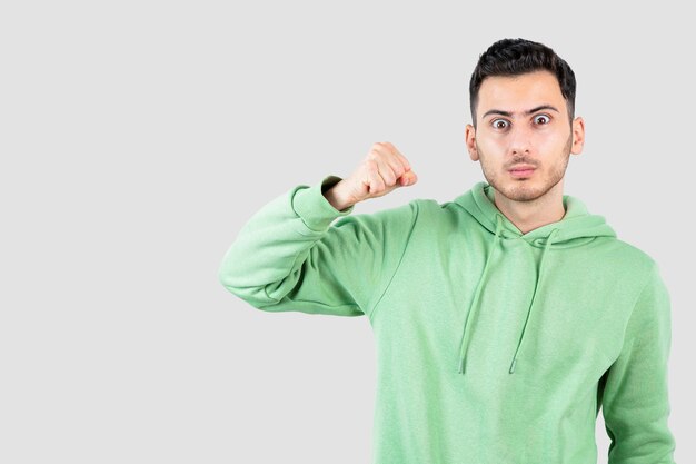 Portrait of male handsome man in hoodie showing his punches