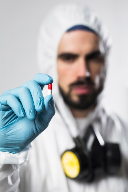 Portrait of male holding colorful capsule