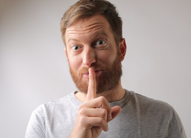 Portrait of a male keeping his finger on his lips