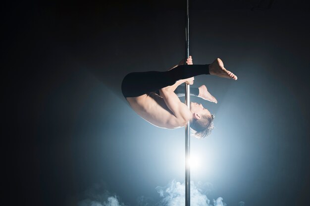 Portrait of male model doing a pole dance