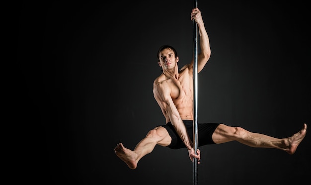 Free photo portrait of male model performing a pole dance