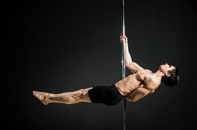 Free photo portrait of male model performing a pole dance