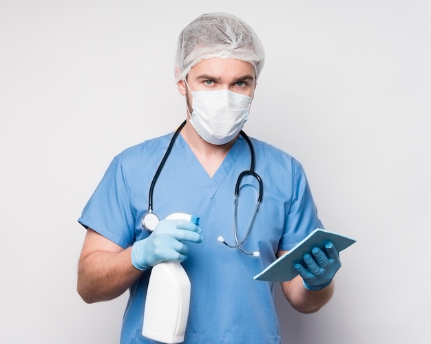 Портрет мужской медсестры с дезинфицирующим средством