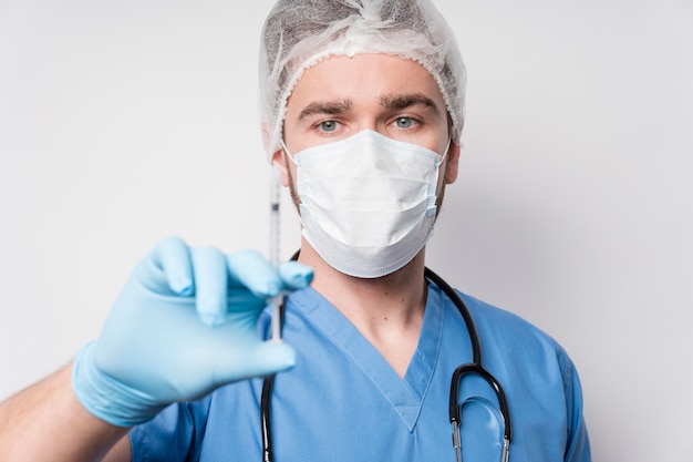 Portrait of male nurse holding syringe