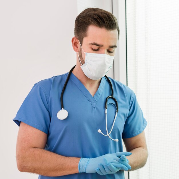 Портрет мужской медсестры в перчатках и маске