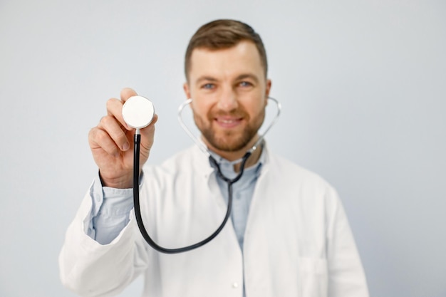 Portrait of a male physician looking at camera holding a stethoscope