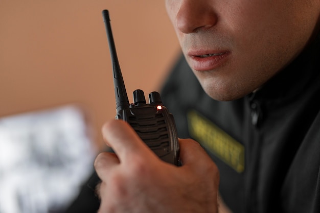 Portrait of male security guard with radio station and camera screens