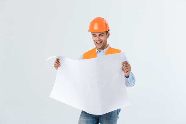 Portrait of male site contractor engineer with hard hat holding blue print paper. Isolated over white background.