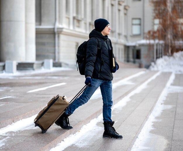 Portrait male student with books and luggage