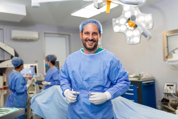現代の病院の手術室でスクラブと医療マスクのカメラドクターを見ている手術室の男性外科医の肖像画