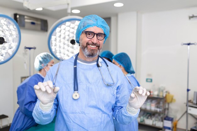 환자를 치료할 준비가 된 수술실에 서 있는 남성 외과 의사의 초상화 수술실에서 남성 의료 종사자 외과 유니폼