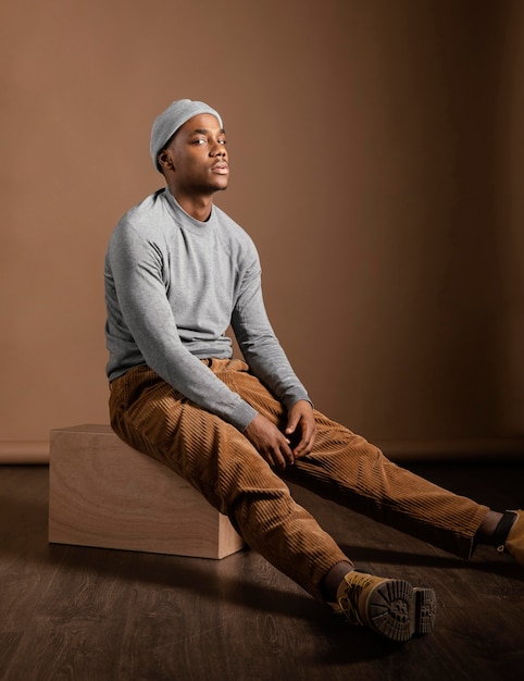 Free photo portrait male wearing cap sitting