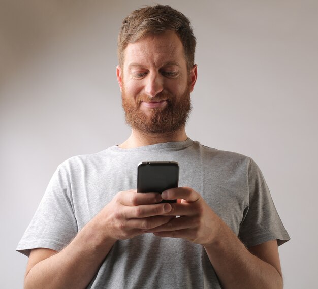 テキストメッセージに興奮しているひげを持つ男性の肖像画