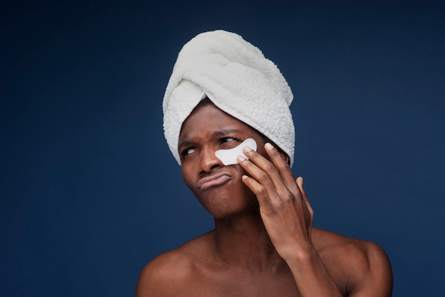 Portrait of a man applying an under eye patch