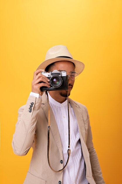 복고풍 카메라로 사진을 찍는 베이지색 정장을 입은 남자 초상화