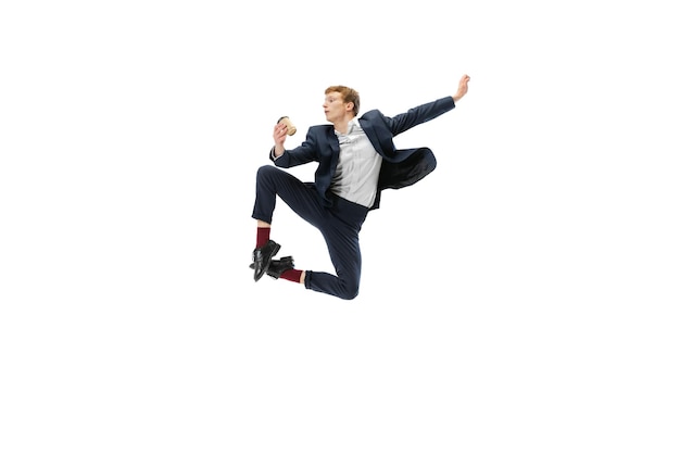 Portrait of man in business style clothes jumping with cup of coffee isolated on white studio background