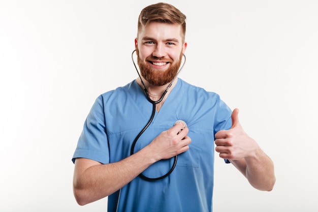 Portrait of man doctor with stethoscope showing thumb up.