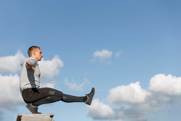 Portrait of  man doing squats with copy space