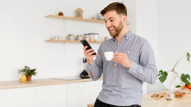 携帯電話をチェックしながらコーヒーを飲む肖像画男