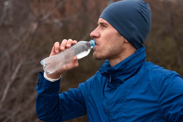 Free photo portrait of man drinking water in nature